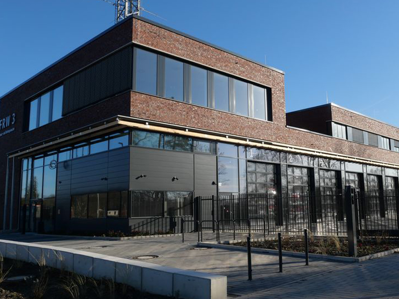 Straßenansicht des zweigeschossigen Ziegelgebäudes mit Wagenhalle und großen Ausfahrtstoren