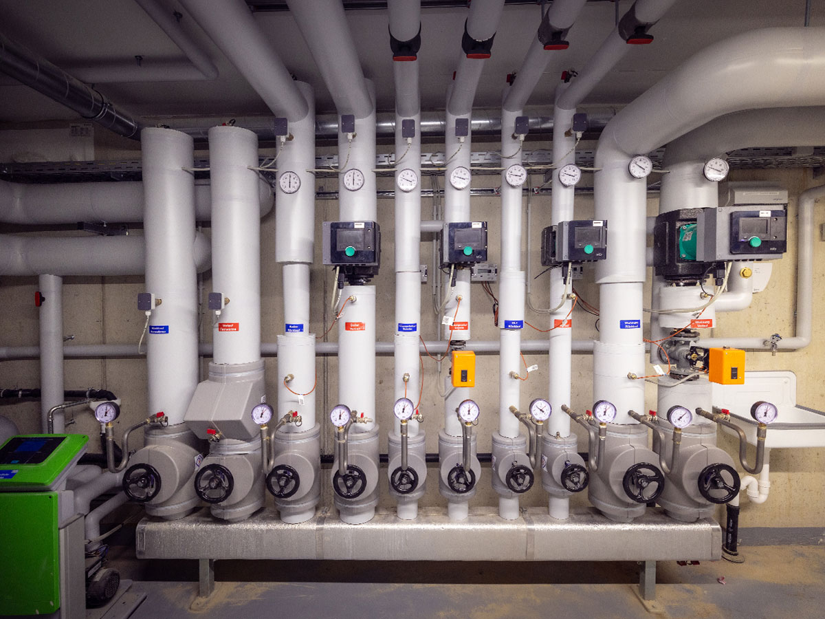Blick auf die technische Anlage im Untergeschoss mit Rohren und Messgeräten